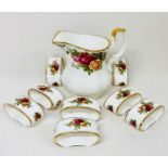 A Royal Albert Country Roses pattern milk jug and eight napkin rings