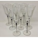 A set of eight wine glass flutes with black tear drop encase steams