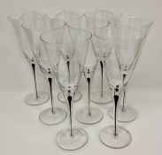 A set of eight wine glass flutes with black tear drop encase steams