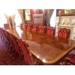 A Sixteen seat mahogany dining table with fourteen chairs and two carvers in red and gold. 540cm