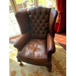 A Brown button back club chair 81cm w x 110cm h x 49cm seat height.