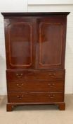 A late Georgian mahogany style linen press, cornice above a pair of panel doors with three long