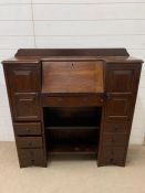 A mahogany hall unit with drop down slope opening to pigeon holes flanked by two cupboards and