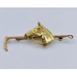 A 9 ct gold brooch in the form of a horse with riding crop (7.4g)