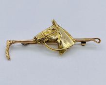 A 9 ct gold brooch in the form of a horse with riding crop (7.4g)