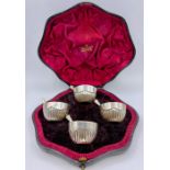 A set of four good quality silver circular salts with fluted decoration & gilded interior, London