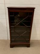 A glazed bookcase/side cabinet on bracket feet (H106cm W56cm D24cm)