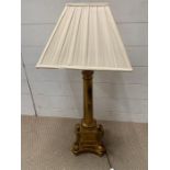 A gilt pillar table lamp and cream shade