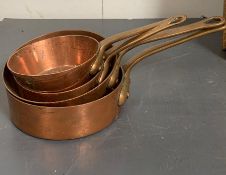 A set of four copper saucepans