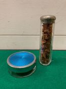 A silver topped glass bottle and a white metal lidded pot