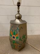 A metal table lamp decorated with a floral theme