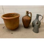 A terracotta urn and plant pot along with a metal jug and bell