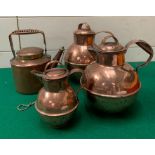Three copper creamer milk jugs and one copper picnic kettle with wicker handle