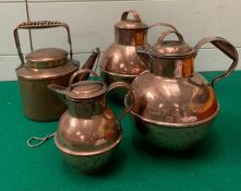 Three copper creamer milk jugs and one copper picnic kettle with wicker handle