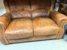 A brown leather two seater sofa