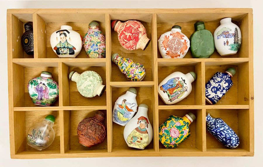 A collection of Chinese scent bottles in a wooden wall hanging display case.