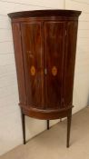 A corner cabinet on stand with string inlay and shell design