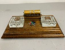 A wooden vintage perpetual desk calendar with two glass inkwell