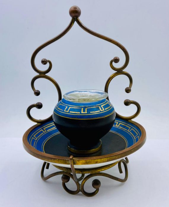 A porcelain inkwell with a geometric design in metal stand