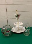 A cake stand along with a glass bowl and jug