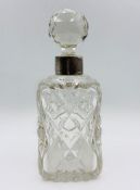 A cut glass scent bottle with silver collar, approx 8" high with stopper. Indistinct hallmarks