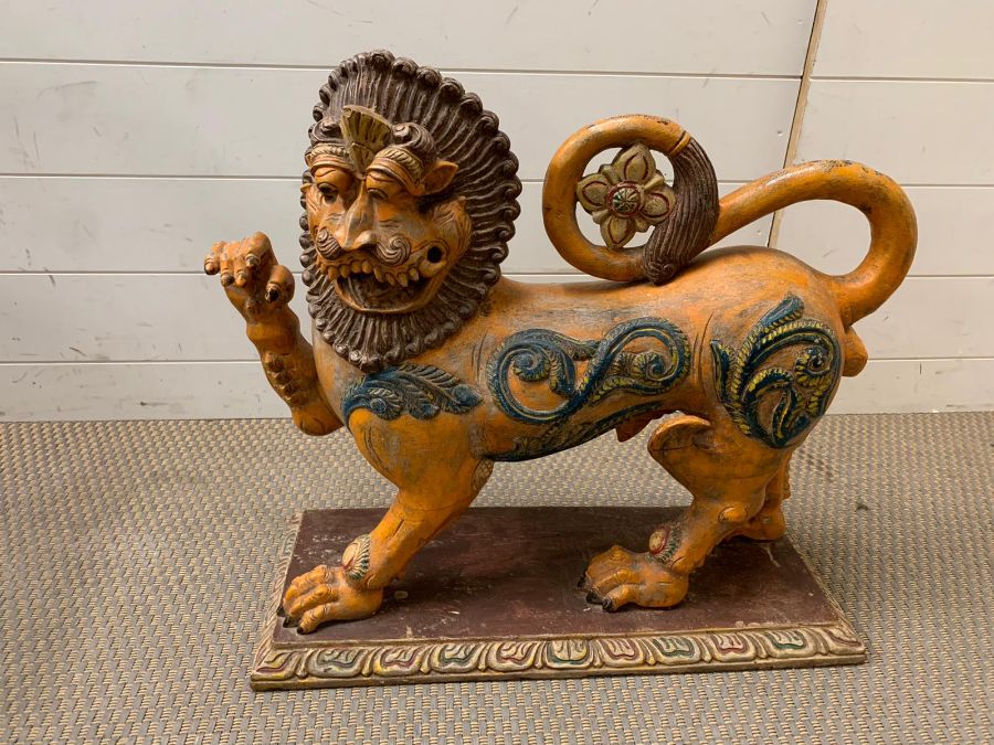 A Mythical lion carved in wood with upraised paw (H57cm W60cm)