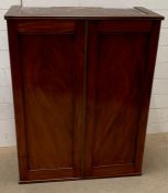 A two door mahogany cabinet converted to hand on a wall