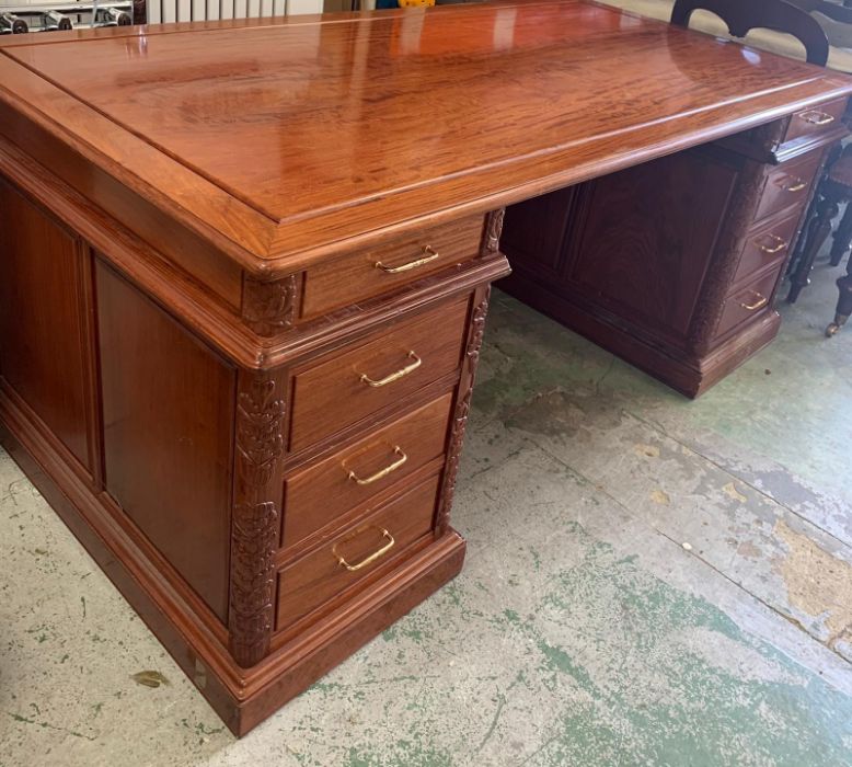A rosewood pedestal desk with carving to door sides and turned metal handles (186cm x 90 cm x 78