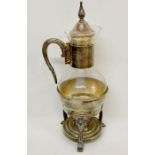 A silver plate and glass coffee/tea pitcher with footed warmer stand.