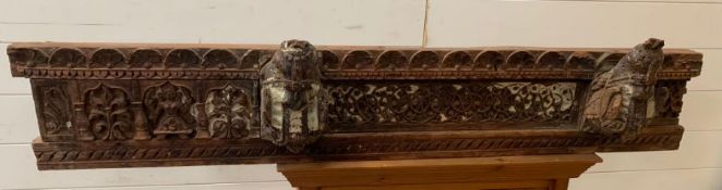 A carved reclaimed wooden beam with carved horses heads, foliage and a tribal figure (136cm x 23cm)