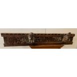 A carved reclaimed wooden beam with carved horses heads, foliage and a tribal figure (136cm x 23cm)