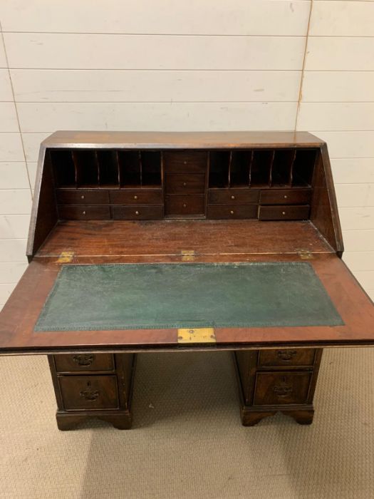 A George III mahogany bureau with sloping fall-front enclosing drawers and pigeonholes, with below 1 - Image 2 of 3