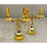 A pair of brass candlesticks, hung with faceted lancet drop glass/ crystal on floral form base