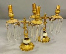 A pair of brass candlesticks, hung with faceted lancet drop glass/ crystal on floral form base