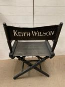 A black folding directors chair named for Keith Wilson Production Designer and Art Director (Long