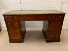 A pedestal desk with brass ring handles and leather top (H70cm W122cm D58cm)