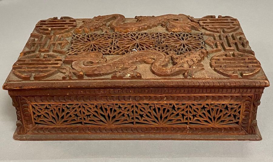 A carved Chinese box with dragon motif.