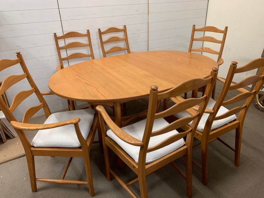 An Ercol dining table and six ladder back chairs