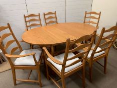 An Ercol dining table and six ladder back chairs