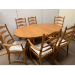 An Ercol dining table and six ladder back chairs