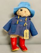 A Paddington bear with blue coat and red boots