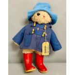 A Paddington bear with blue coat and red boots