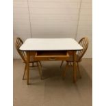 A Mid Century kitchen table with two pine spindle back chairs