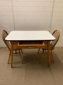 A Mid Century kitchen table with two pine spindle back chairs