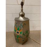 A metal table lamp decorated with a floral theme