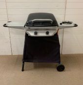 A gas barbecue with hob burner to side