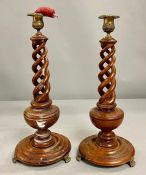 A pair of mahogany twisted/candlesticks with brass top and feet