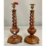 A pair of mahogany twisted/candlesticks with brass top and feet