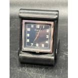 An Asprey travel clock in Black leather holder.