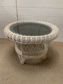 A glass topped wicker coffee table (H44cm Dia64cm)